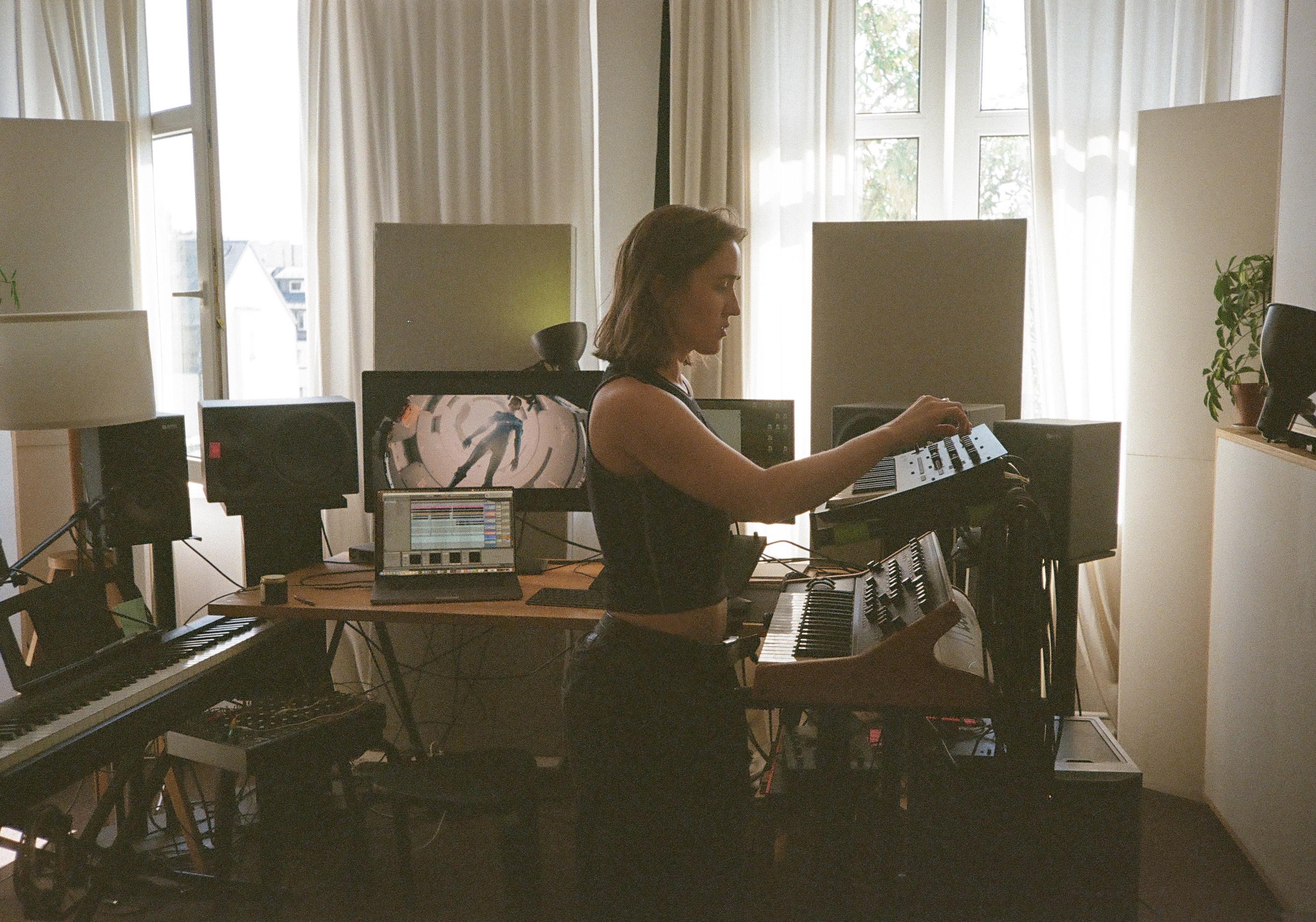 Wioleta Wnorowska in her studio surrounded by keyboards, speakers and music equipment